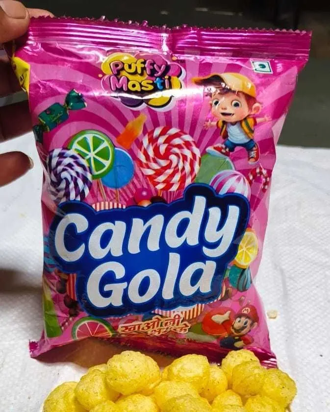 Candy Gola ₹5 packet from Puffy Masti, held in hand with the snack tipped out below