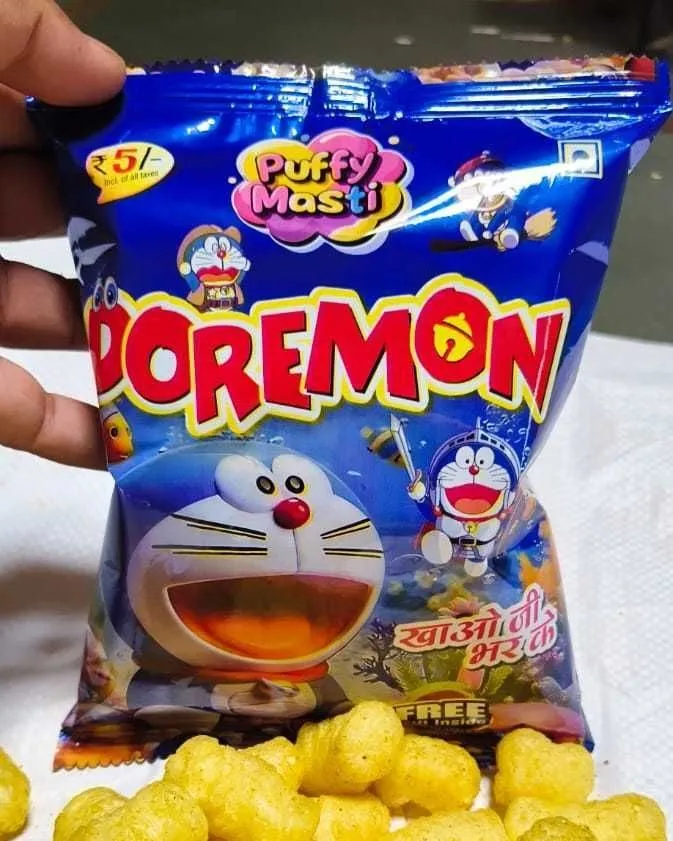 Doremon ₹5 packet from Puffy Masti, held in hand with the snack tipped out below