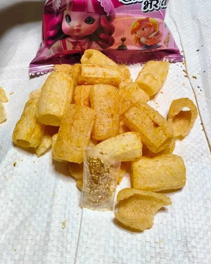 The Gold-tone jewellery set that comes sealed inside a Gudiya Rani pack, sitting among the snack