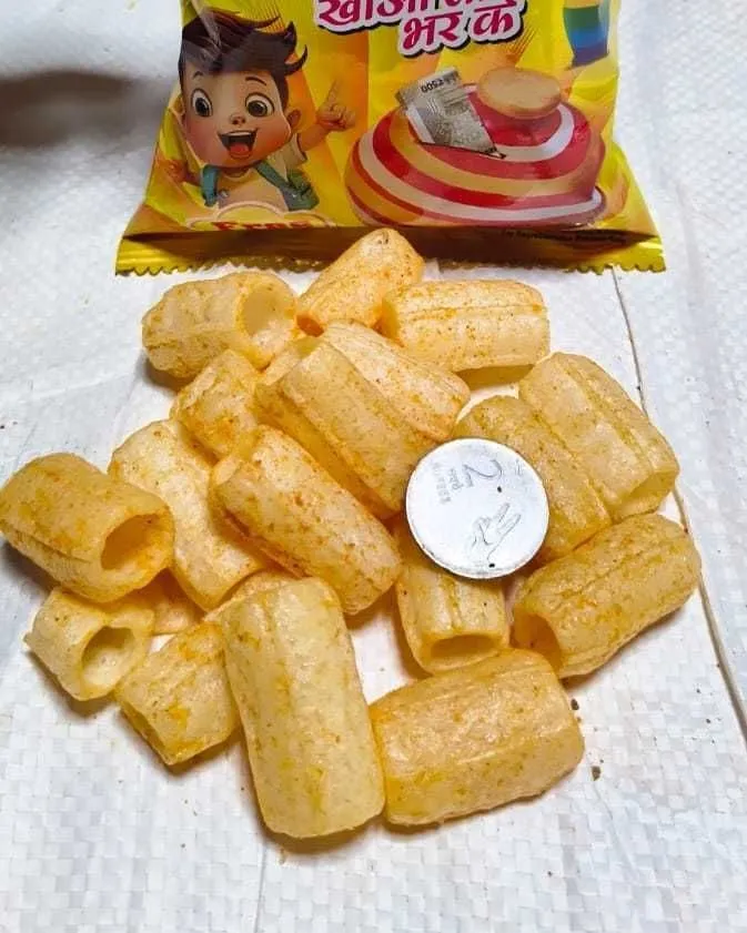 The A real ₹2 coin that comes sealed inside a Gullak pack, sitting among the snack