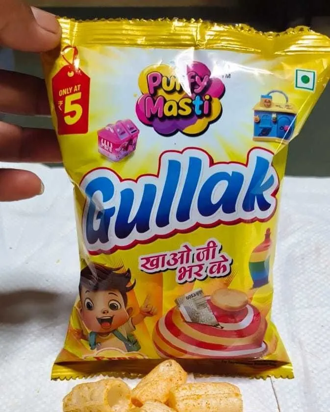 Gullak ₹5 packet from Puffy Masti, held in hand with the snack tipped out below