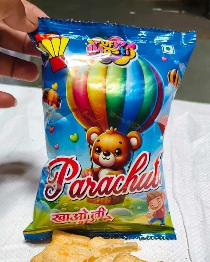 Parachute ₹5 packet from Puffy Masti, held in hand with the snack tipped out below