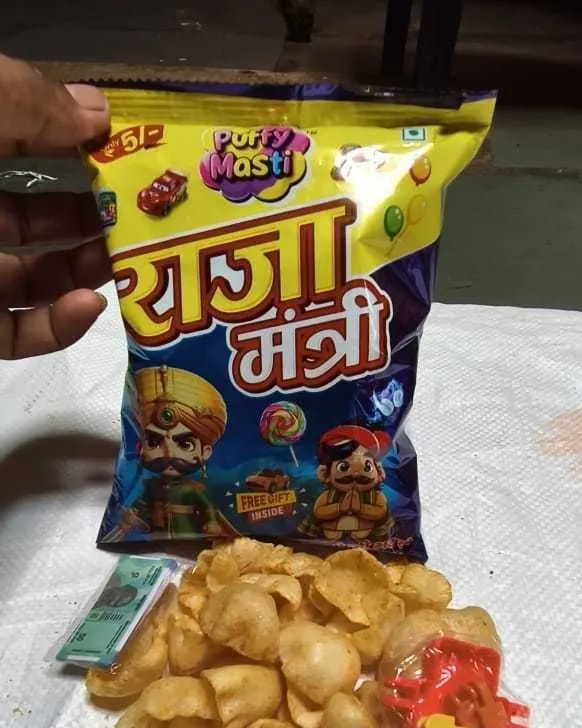 Raja Mantri ₹5 packet from Puffy Masti, held in hand with the snack tipped out below